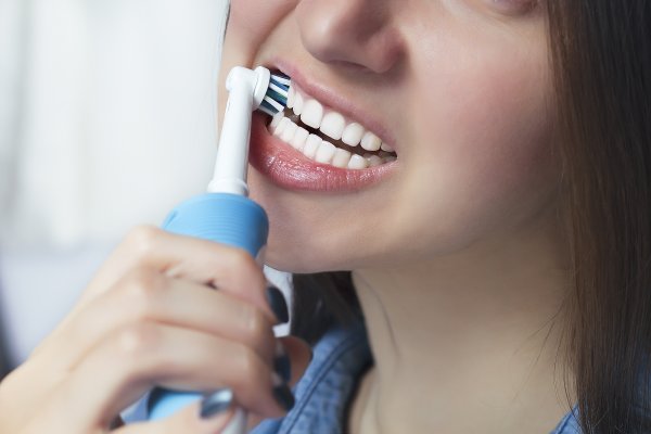 Person using electric toothbrush